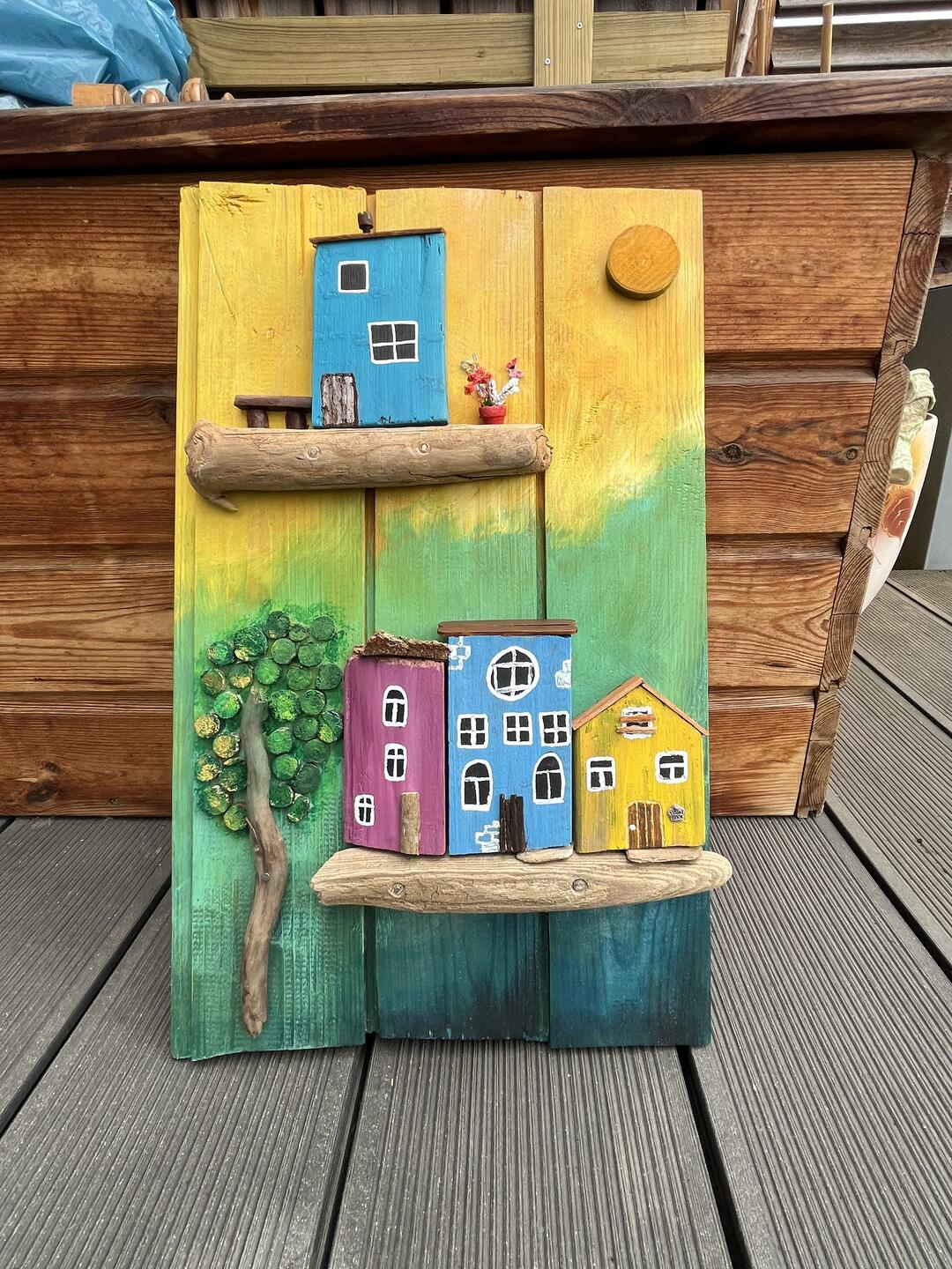 Decorazione in legno dipinta a mano — casette colorate su mensole di legno di mare, un albero e un sole su sfondo giallo, verde e blu — foto 2 / 4